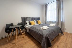 a bedroom with a bed and two chairs and a window at Apartamenty Słowackiego 16 in Poznań