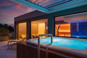 a hot tub in a house with a patio at Corallo Wellness Hotel in Diano Marina