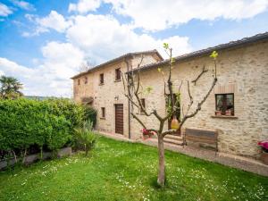 a stone house with a tree in the yard at Farmhouse in IL VECCHIO FORNO UMBRO Citta di Castello in San Secondo