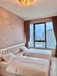 2 camas en un dormitorio con ventana grande en شقه فارهه ومكيفه بالكامل, en Estambul