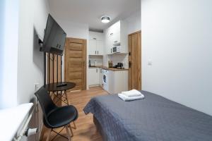 Schlafzimmer mit einem Bett, einem Schreibtisch und einem TV in der Unterkunft Apartamenty Słowackiego 16 in Posen