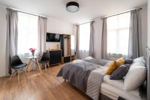 1 dormitorio con 1 cama y 1 mesa con sillas en Apartamenty Słowackiego 16 en Poznan
