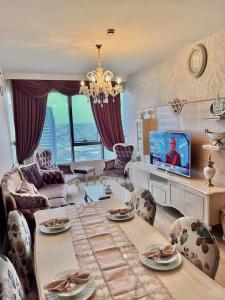 salon z telewizorem, stołem i krzesłami w obiekcie شقه فارهه ومكيفه بالكامل w Stambule