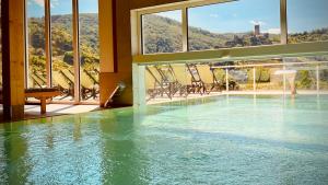 einen Pool mit Wasser in einem Gebäude mit Fenstern in der Unterkunft Mosel Village Resort in Ellenz-Poltersdorf