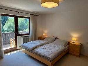a bedroom with a bed and a large window at Gemütliche Ferienwohnung mit Blick ins Grüne in Zwiesel