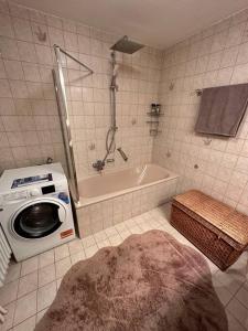 a bathroom with a washing machine and a bath tub at Gemütliche Ferienwohnung mit Blick ins Grüne in Zwiesel