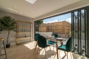 a dining room with a glass table and green chairs at 4 Bedrm House Greater London in London