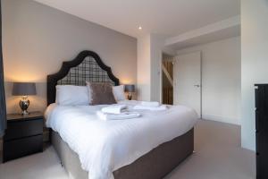 ein Schlafzimmer mit einem großen Bett mit zwei Handtüchern darauf in der Unterkunft 4 Bedrm House Greater London in London