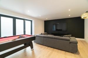 ein Wohnzimmer mit einem Billardtisch und einem Sofa in der Unterkunft 4 Bedrm House Greater London in London