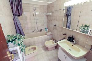 un bagno con lavandino, WC e vasca di Logement chaleureux au coeur de la station a Crans-Montana Altre 22 foto