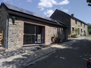 a brick building with a window on a street at L'île d'Amélie in Ciney