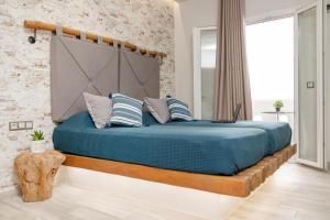 un letto con lenzuola e cuscini blu in una stanza di Katerina Roza Studios a Naxos Chora