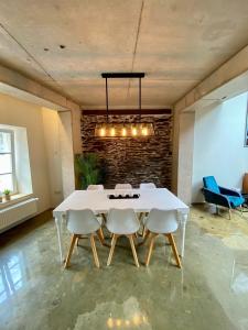 a dining room with a white table and chairs at Ancien Cinema Loft in Vianden