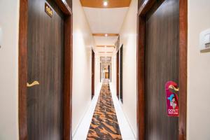 un corridoio con un lungo corridoio con due porte e uno skateboard di FabExpress Orange Suite a Mumbai