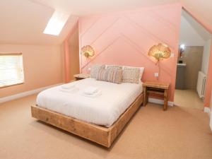 a bedroom with a large bed with pink walls at The Workshop in Northallerton