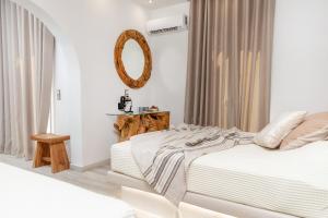 una camera bianca con letto e specchio di Katerina Roza Studios a Naxos Chora