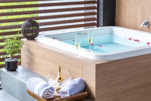 a bath tub with two glasses of wine and towels at Fabulous & Exclusive Apartments With Sea View Pool BBQ Garden in Akumal