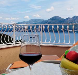 un bicchiere di vino seduto su un tavolo sul balcone di Villa Stanović Tea a Cavtat