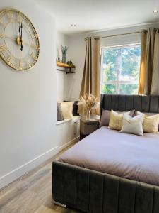 sypialnia z dużym zegarem na ścianie i łóżkiem w obiekcie Apartment in Stepney Green w Londynie