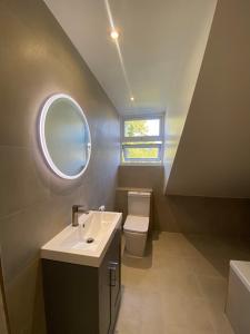 a bathroom with a sink and a toilet and a window at Apartment in Stepney Green in London