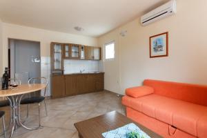 a living room with a couch and a table and a kitchen at Apartments Alajbeg in Trogir