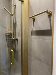 a shower with a glass door in a bathroom at Apartment in Stepney Green in London