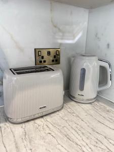 un four micro-ondes et un grille-pain assis sur un comptoir dans l'établissement Apartment in Stepney Green, à Londres