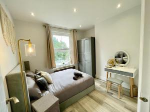 um quarto com uma cama, uma mesa e um espelho em Apartment in Stepney Green em Londres