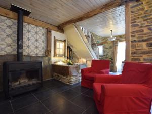 JehonvilleにあるBeautiful holiday home in Belgiumのリビングルーム(暖炉、赤い椅子付)