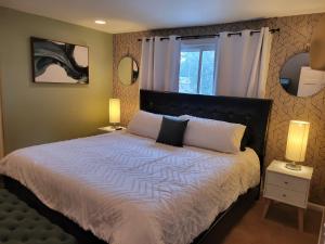 a bedroom with a large bed with two lamps at 160inch Home Movie Theater- Great for movie night! in Omaha