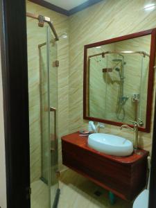 y baño con lavabo y ducha con espejo. en Lotus Corner - Vegan & Plant Based B&B, en Luang Prabang