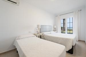 アルクーディアにあるVilla Garballo Alcudia - Sea Frontの白い部屋 ベッド2台 窓付