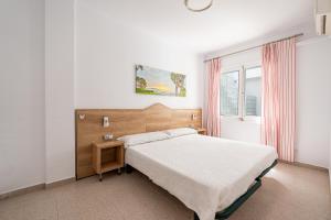 アルクーディアにあるVilla Garballo Alcudia - Sea Frontの白いベッドルーム(ベッド1台、窓付)