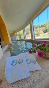two white towels sitting on the floor next to a swimming pool at B&B La Chintina in Sant Antonio Di Gallura