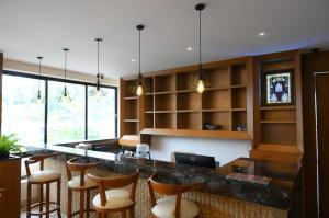 uma cozinha com um bar com armários de madeira e bancos de bar em SHRREYAS INN em Kundapur
