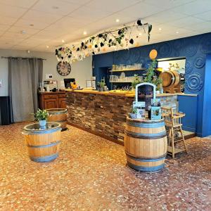 um restaurante com um bar com barris numa sala em Logis L'Auberge du Gros em Silly-sur-Nied
