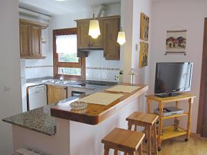 a kitchen with a kitchen island with a tv on it at Les LLaus in Ribera de Cardós