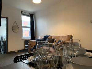 a table with glasses on it with a couch at Saltwell St - Delightful 3 Bedroom free parking free wifi in Gateshead