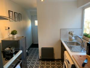 a kitchen with a sink and a counter top at Saltwell St - Delightful 3 Bedroom free parking free wifi in Gateshead +10 photos