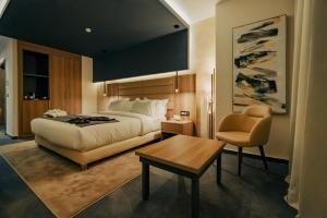 阿爾及爾的住宿－AD HOTEL HYDRA，卧室配有1张床、1张桌子和1把椅子