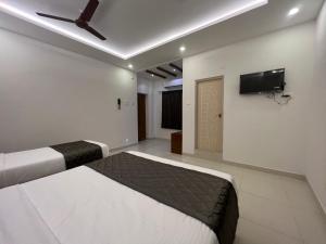 1 dormitorio con 1 cama y ventilador de techo en Le Hotel Host en Tiruchchirāppalli