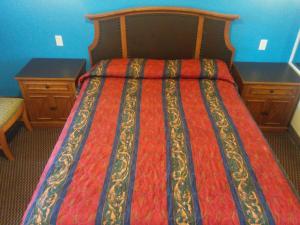 1 dormitorio con 1 cama y 2 mesitas de noche en Sunshine Motel, en San Bernardino