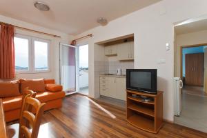a living room with a couch and a television at Apartments Alajbeg in Trogir