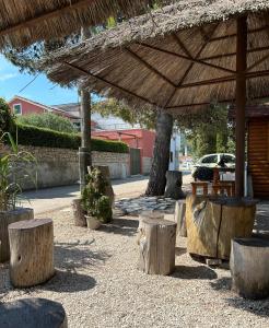 a group of wooden stools under a large umbrella at Zio Nino in Sutomišćica