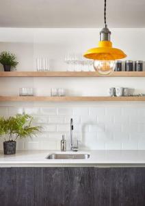 a kitchen with a sink and a pendant light at The Chapel Cottage by Ritual Stays in Hemel Hempstead