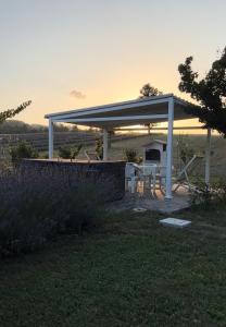a pavilion with a table and a grill in a field at la baita nei boschi in Serramazzoni