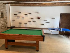a room with a pool table in front of a wall at Chambre double avec salle de bains privée in Quintin