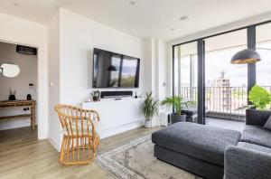 ein Wohnzimmer mit einem Sofa und einem Stuhl in der Unterkunft Modern 1 bed l City views l Work Space in London