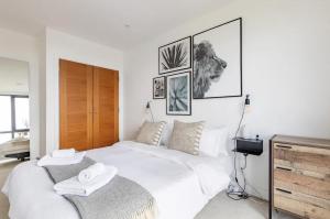 a bedroom with a large white bed with two towels on it at Modern 1 bed l City views l Work Space in London
