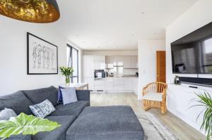 sala de estar con sofá gris y cocina en Modern 1 bed l City views l Work Space, en Londres